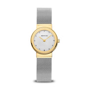 A Bering classic collection watch with a polished gold-colored case, silver-colored milanese strap, and a silver dial with SWAROVSKI ELEMENTS.